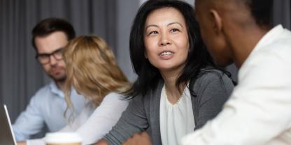 Women talking with colleagues in boardroom setting